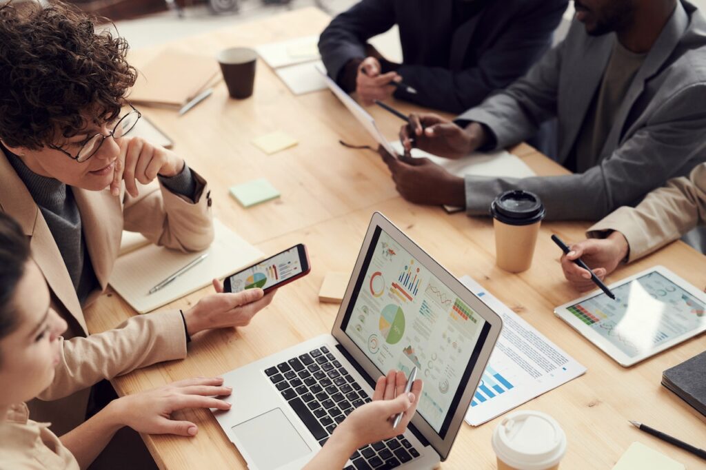 people sitting at a table looking at a computer; SEO for Small Businesses by Harv Communications in Ontario